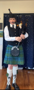 Bagpiper in kilt indoors