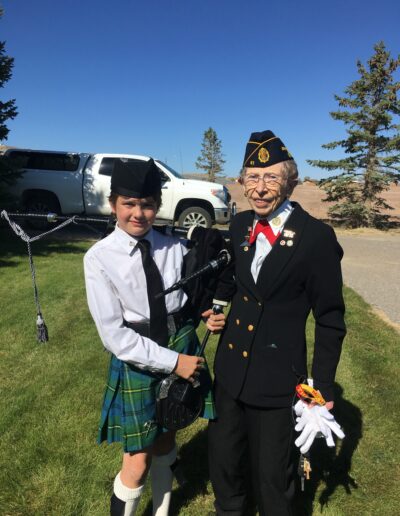 Youth piper receiving a pin from Veteran Honor Guard leader.