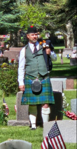 Piper standing in cemetery for Memorial Day performance