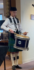 Snare drummer performing indoors at memorial service