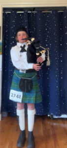 Bagpiper with competition number on kilt