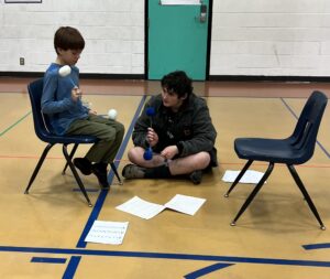 Youth band member teaching a youth beginner